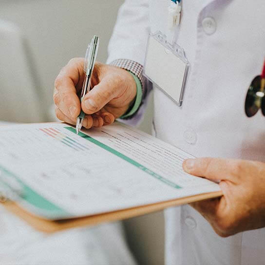 Urgent care physician in Niles, IL documenting patient symptoms – comprehensive diagnosis and treatment of acute and chronic health conditions at CareCentrics Urgent Care