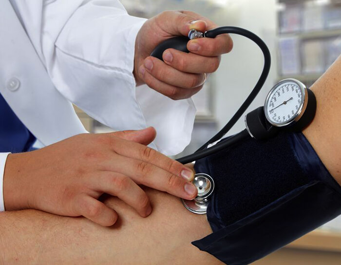 Doctor measuring blood pressure with sphygmomanometer — routine checkup and primary care at Marpeh Urgent Care in Niles, IL