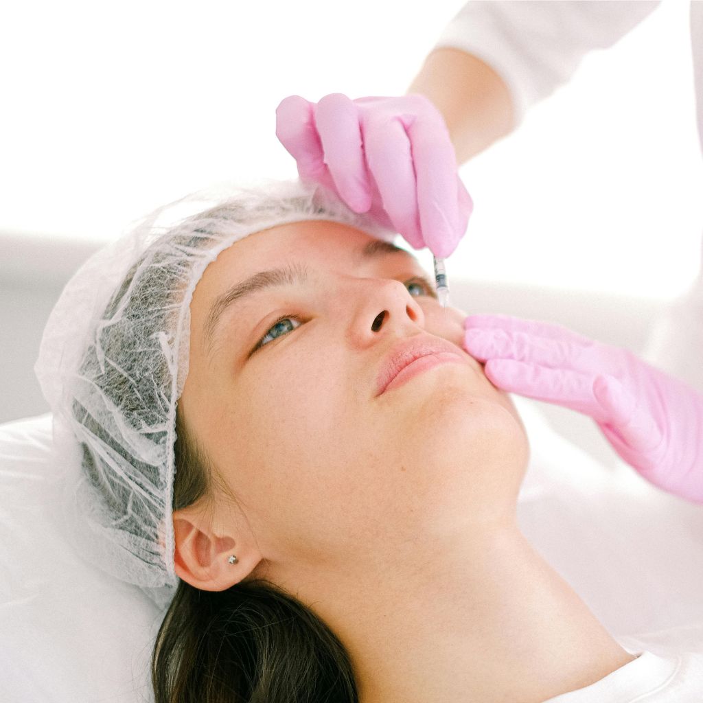 Dermal fillers treatment procedure with gloved hands applying non-surgical cosmetic injection for facial rejuvenation.